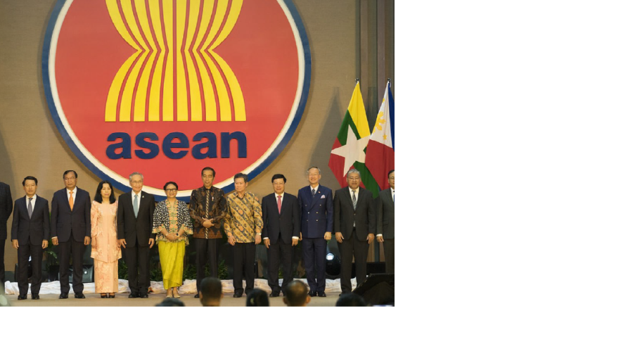Group of people on stage with the ASEAN logo and flags behind them.